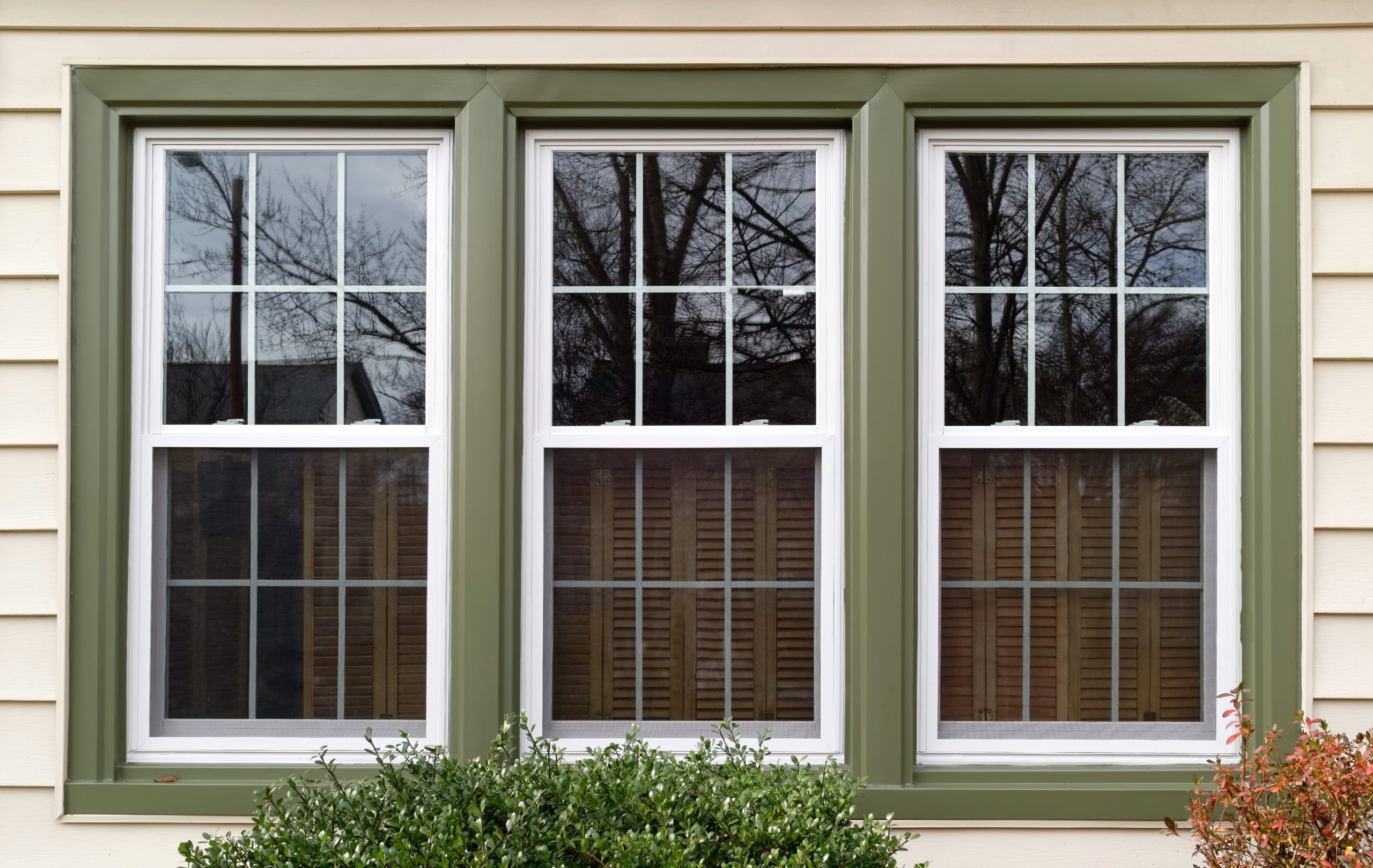 Three single-hung windows with green frames and white grids