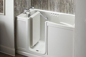 Close-up image of a walk-in tub with silver fixtures and various safety accessories.